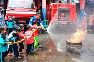 Petugas Damkar saat mengajar anak PAUD padamkan api.